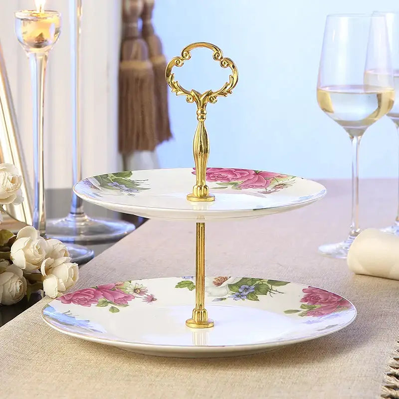 Elegant two-tiered fruit plates set with gold-toned ornate handle and pink rose floral patterns on white ceramic plates