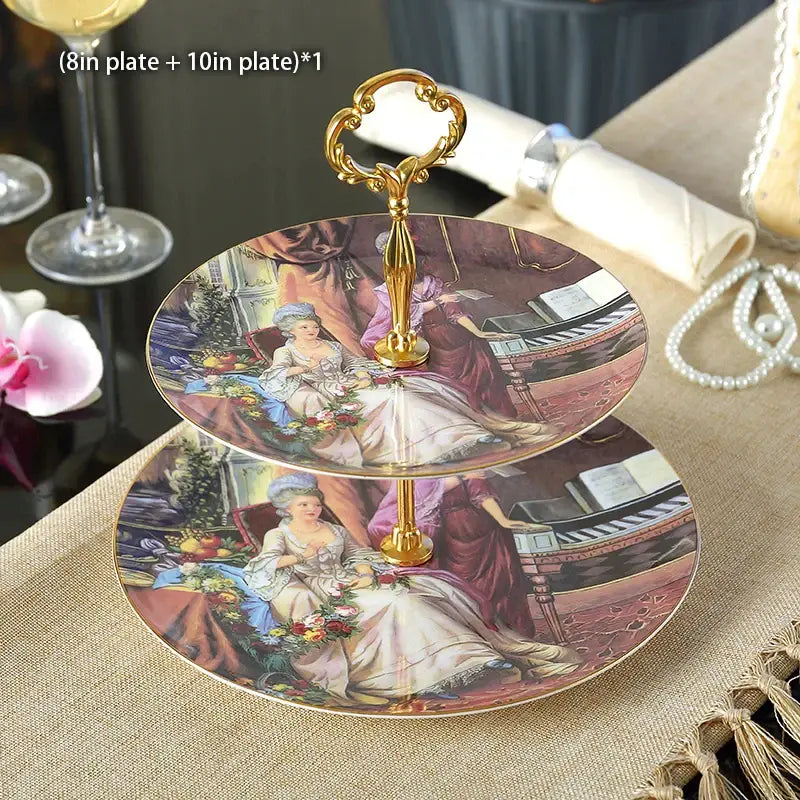 Two-tiered fruit plates set with ornate gold handle and vintage porcelain plates featuring 18th-century ladies gowns