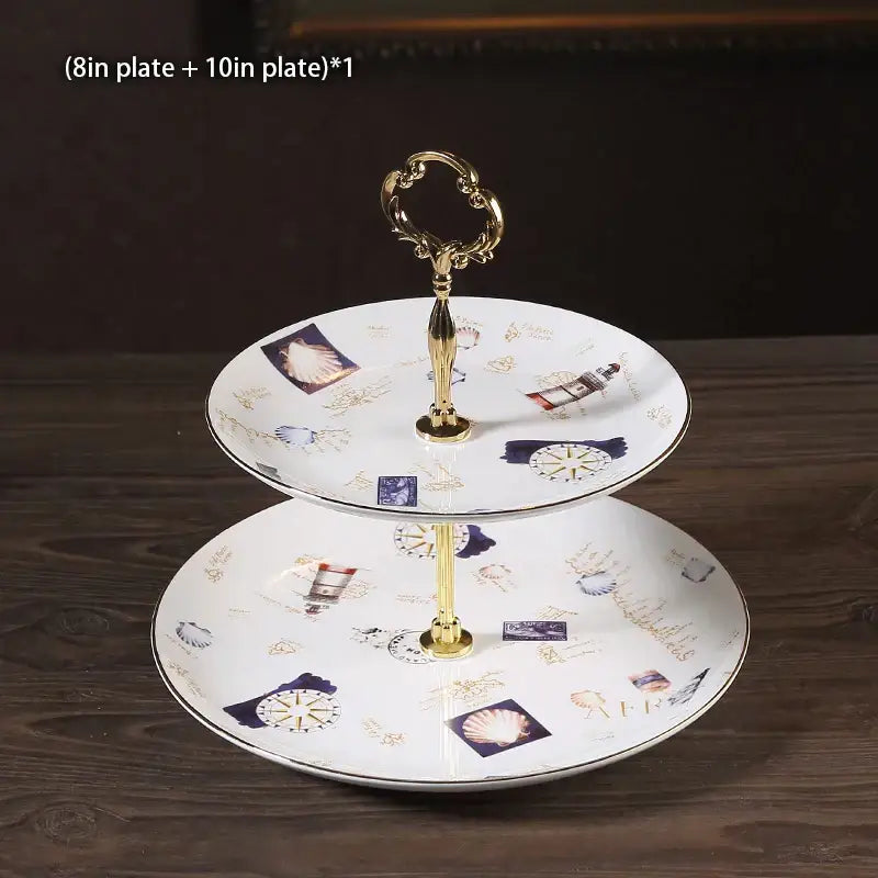 Two-tiered ceramic fruit plates set with gold-toned metal handle and nautical illustrations on white porcelain plates