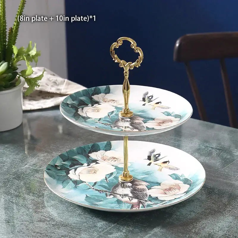 Ornate gold three tiered ceramic fruit plates set with teal white and pink bird and flower design and handle