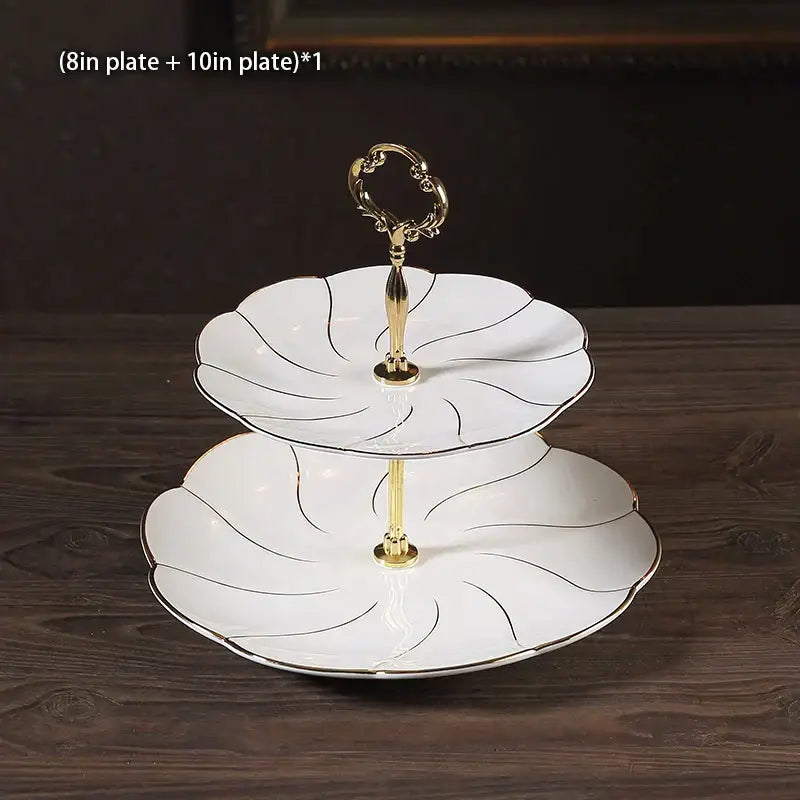 White porcelain two-tier fruit plates set with gold-trimmed floral edges and ornate golden handle dining room stand