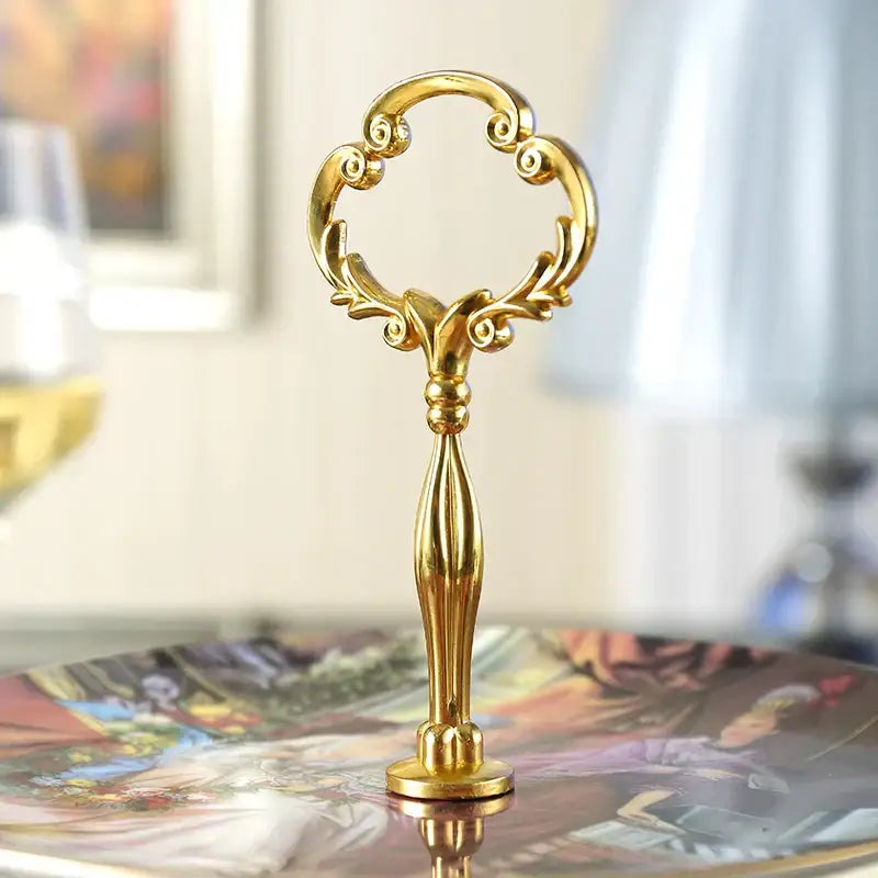 Ornate gold three tiered floral fruit plates set with a golden key shaped stand and intricate scrollwork finish
