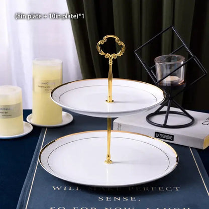 Ornate gold three tiered metal stand with white ceramic fruit plates set edged in gold trim for dining room use
