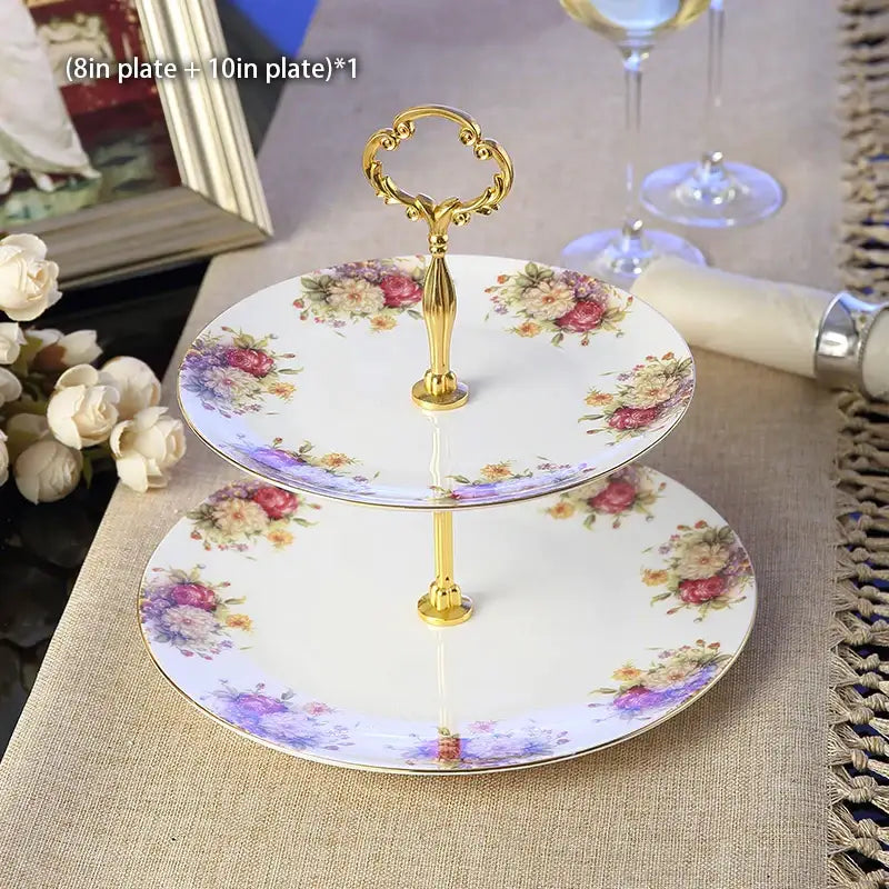 Two-tiered porcelain fruit plates set with gold ornate handle and floral patterns on white dining room stand