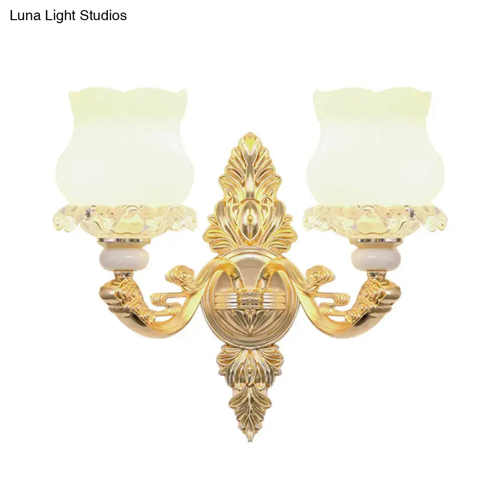 Ornate gold wall light fixture with glass bloom frosted shades and elegant design suitable for living room use