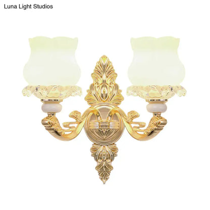 Ornate gold wall light fixture with glass bloom frosted shades and elegant design suitable for living room use