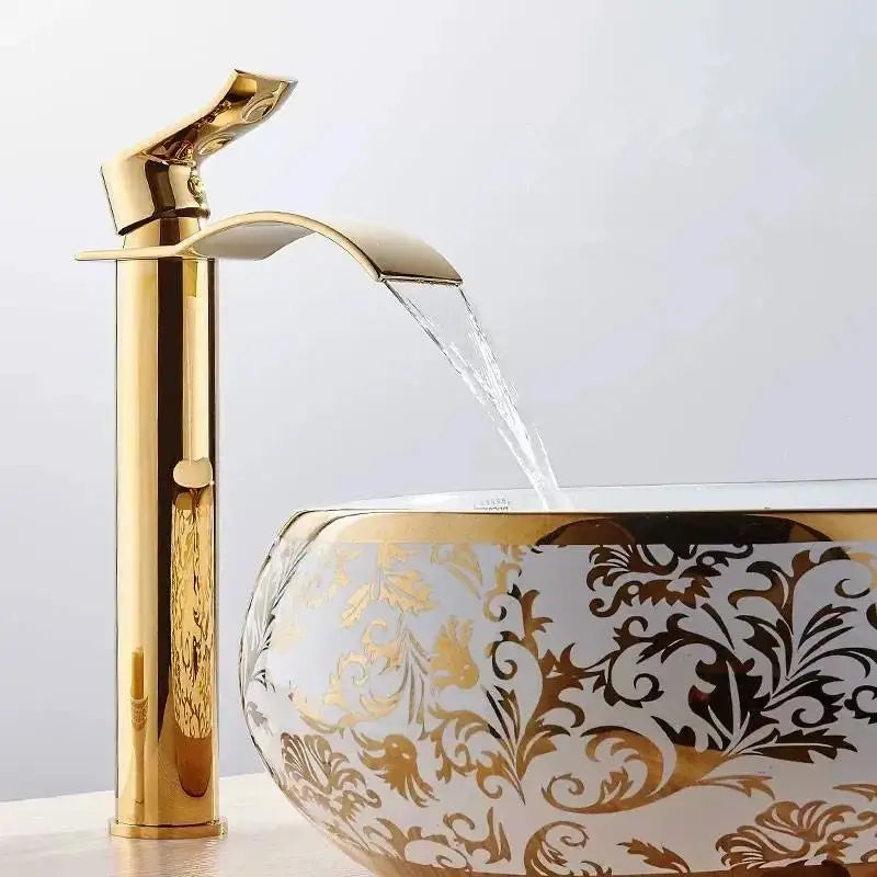 Ornate gold waterfall bathroom faucet with high-arc design pours water into floral decorbites gold waterfall basin