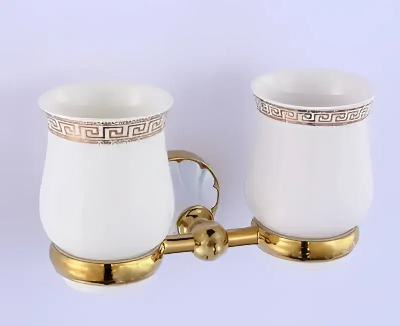 Ornate gold finished toothbrush holder with two white ceramic cups featuring greek key pattern decorbites bathroom accessories
