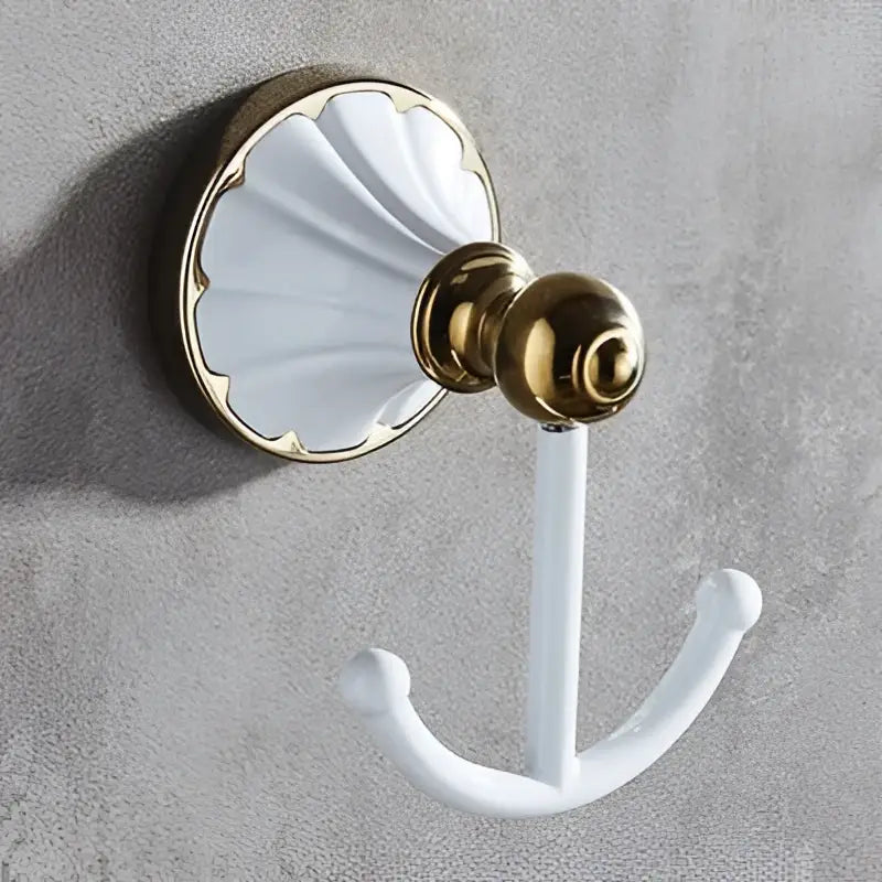 White ceramic hook with gold-toned metal base and shell-shaped backplate from decorbites bathroom accessories set