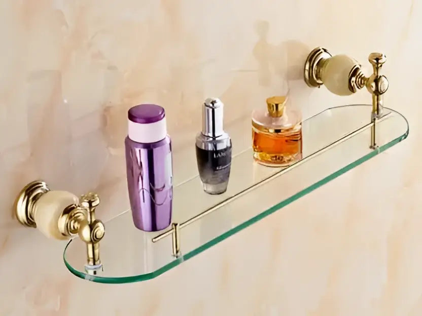 Glass shelf with brass jade decorbites hardware set featuring cream ceramic end caps holding three perfume bottles