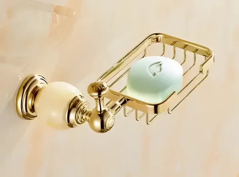 Ornate gold-toned metal soap dish with cream ceramic knob holding pale green soap from decorbites brass jade bathroom hardware set