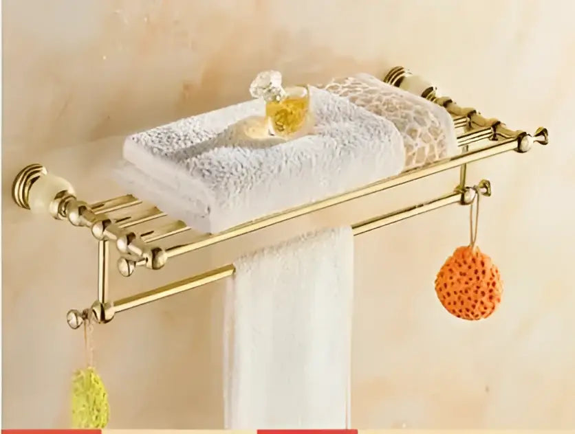 Ornate gold-toned bathroom towel rack with clear glass shelf and decorative finials from decorbites brass jade hardware set