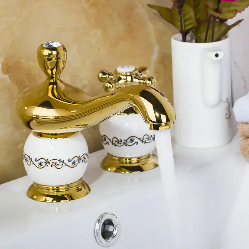 Ornate gold and white porcelain bathroom faucet set with blue floral patterns and diamond bathroom faucet accent
