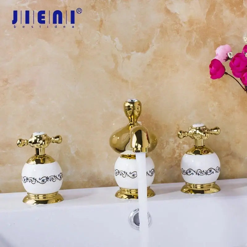 Ornate gold and white porcelain bathroom faucet set with gold-finished ceramic and black scrollwork detailing