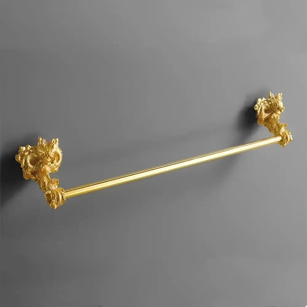 Gold-colored towel rack with ornate dragon head finials in an ornate golden dragon bathroom hardware set with white ceramic