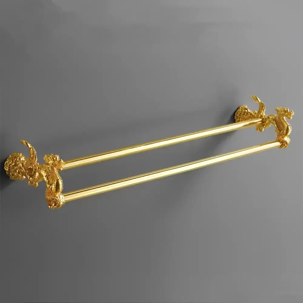 Gold-colored double towel rack with ornate dragon head finials in bathroom hardware set with white ceramic accents