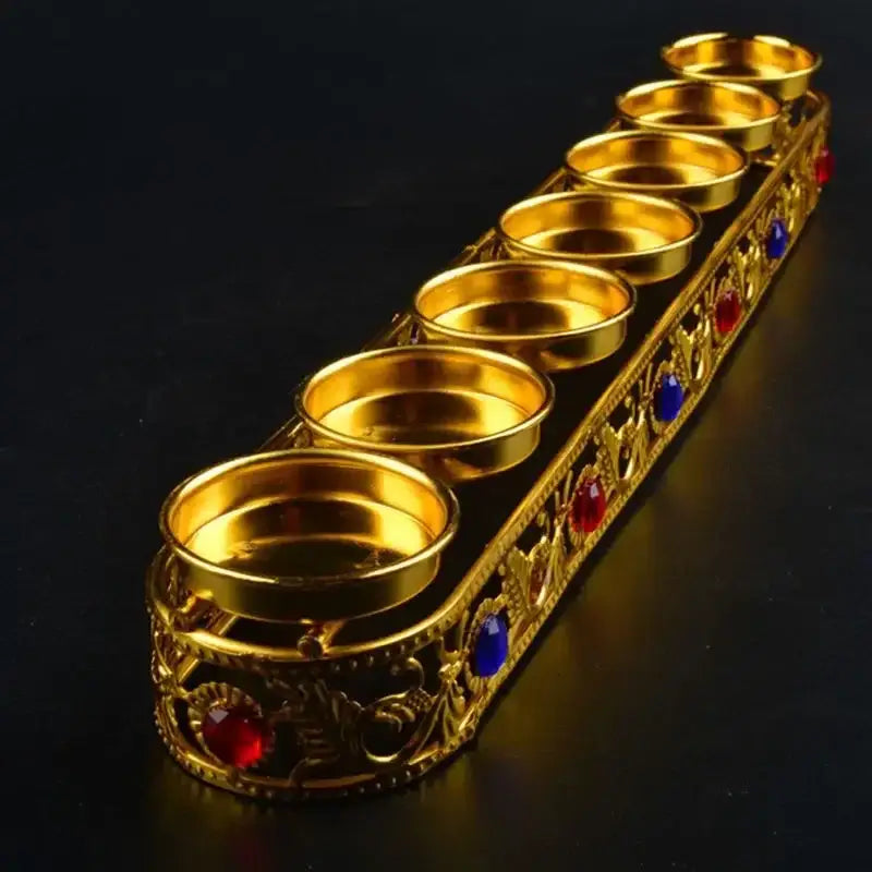 Ornate golden gem inlaid candlestick stand with six compartments decorated with red and blue gemstones for wedding decor