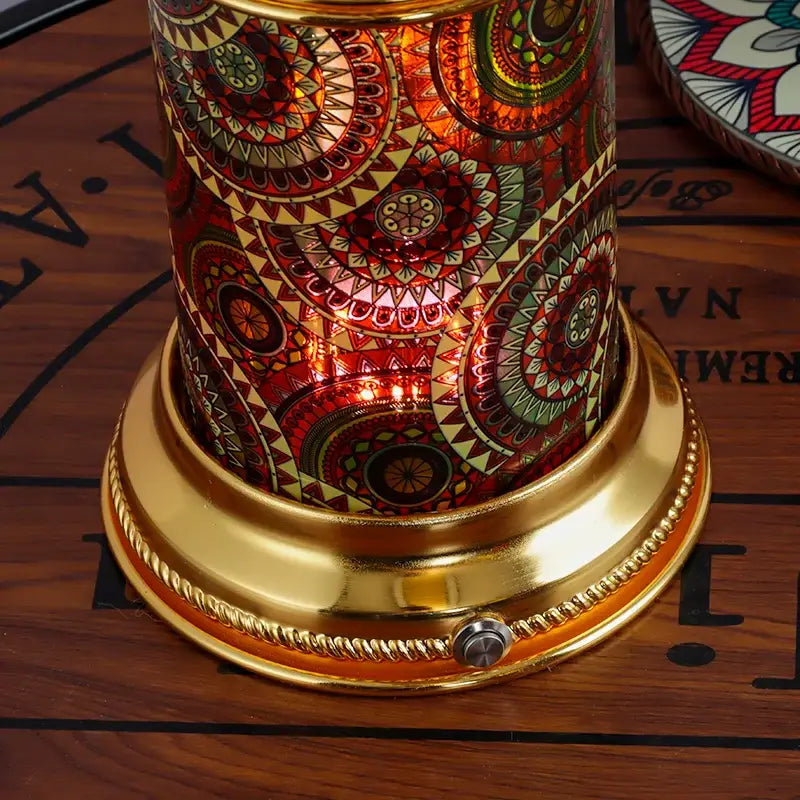 Ornate golden mosaic fruit platter desk lamp with a cylindrical glass candle holder featuring red gold and green mandala decorbites fruit platter design