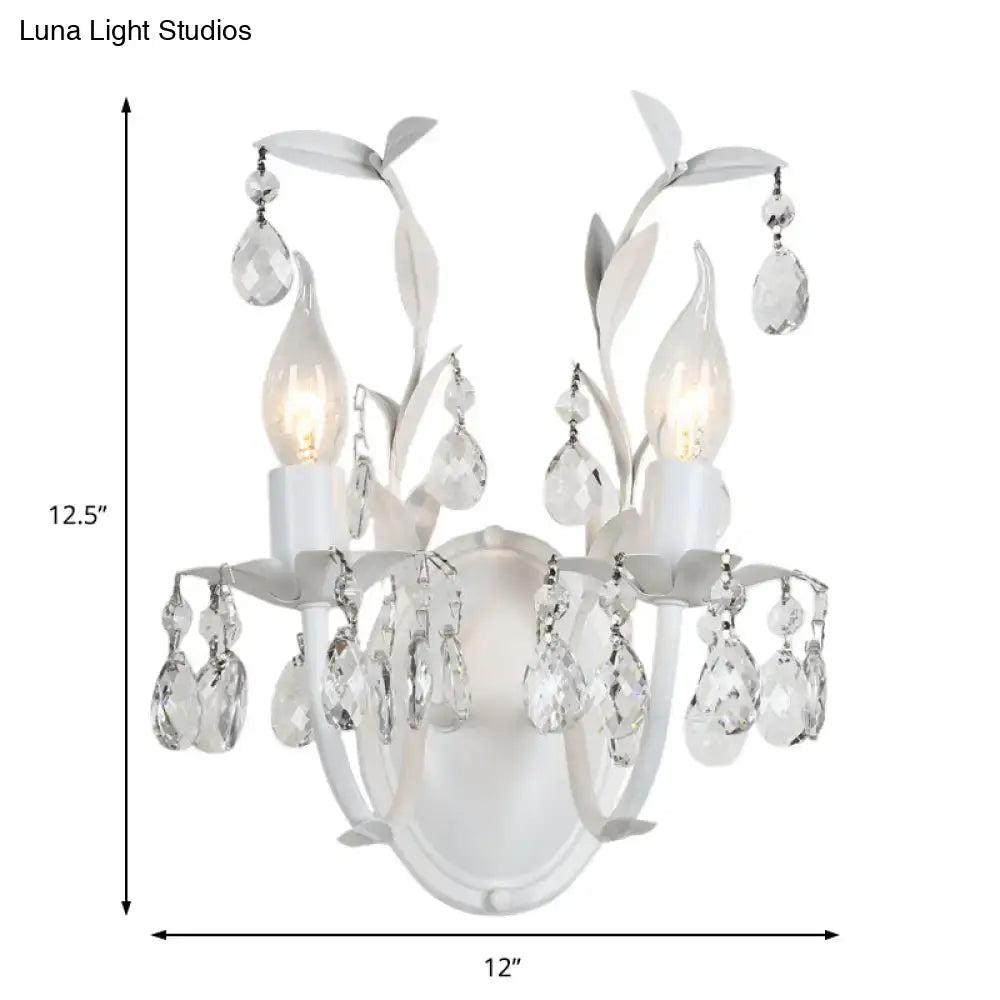 Ornate silver crystal leaf wall light fixture with white floral design and two illuminated light fixtures for bedroom use