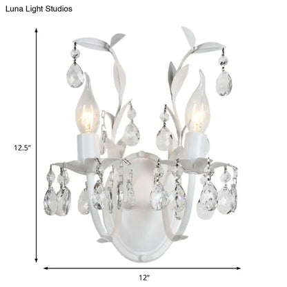 Ornate silver crystal leaf wall light fixture with white floral design and two illuminated light fixtures for bedroom use