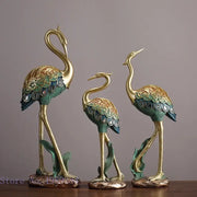 Ornate teal and gold crane bird sculpture with intricate feather patterns for living room decor by decorbites