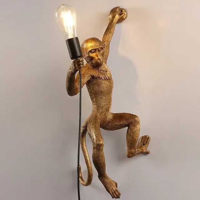 Ornate white monkeys pendant chandelier featuring a golden monkey wall lamp holding a lit bulb for living room decor