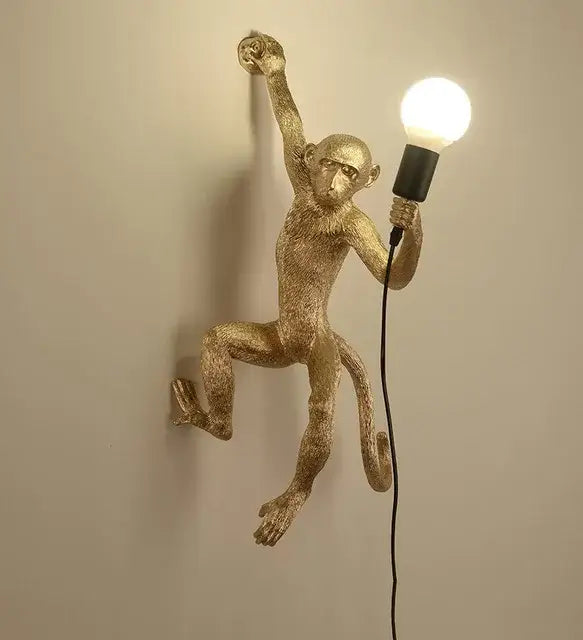Gold-colored monkeys pendant chandelier with textured finish holding an exposed bulb for living room decor