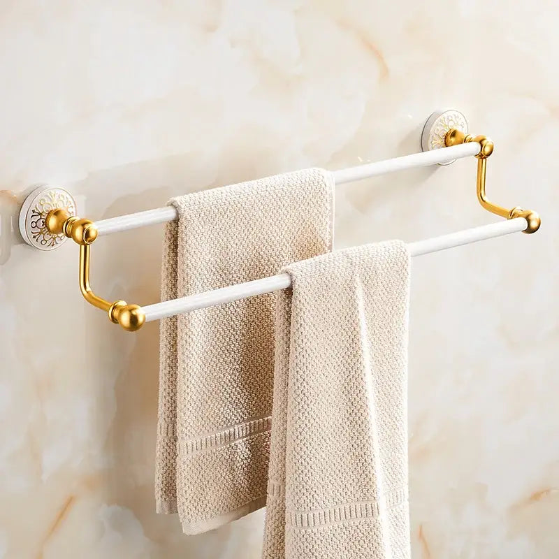 Ornate white and gold double towel rack with textured beige towels in decorbites bath hardware set for bathroom decor