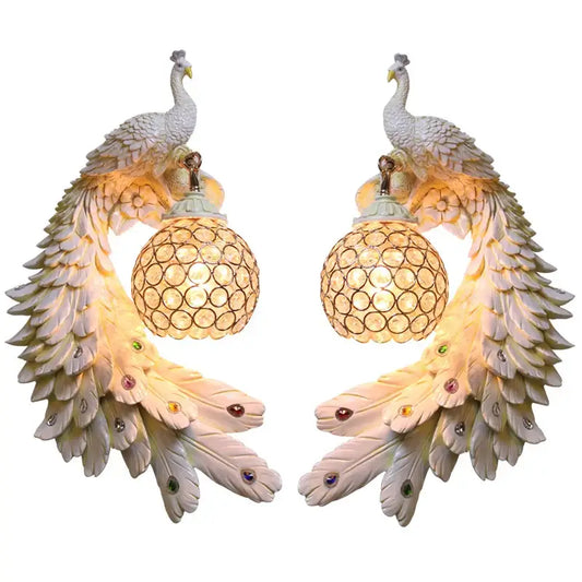 Pair of ornate white gold peacock crystal wall lamps with iridescent feathers and crystal-encrusted globe shades decorbites gold peacock