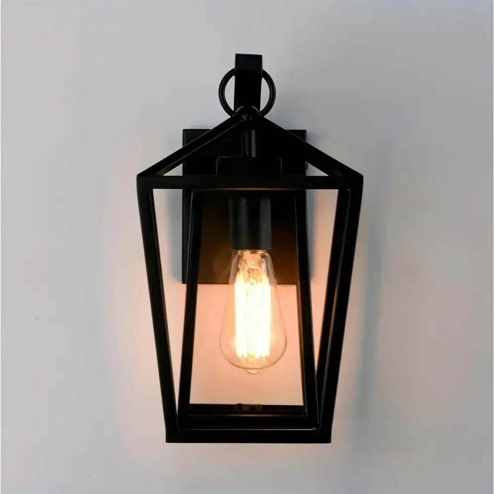 Black wrought iron outdoor wall light with glass shades featuring a glowing filament bulb for outdoor wall use