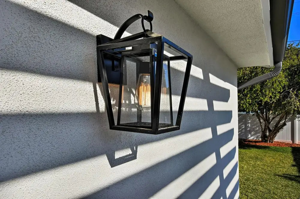Black wrought iron outdoor wall light with glass shades and filament bulb for waterproof outdoor use