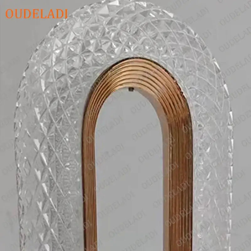 A clear arched mirror with faceted crystal frame and polished copper border complements decorbites crystal bedroom table lamp