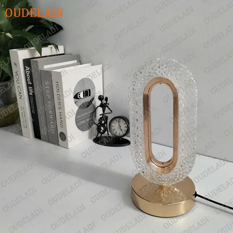 A modern oval-shaped crystal bedroom table lamp with textured clear glass and rose gold frame for decorbites crystal bedroom
