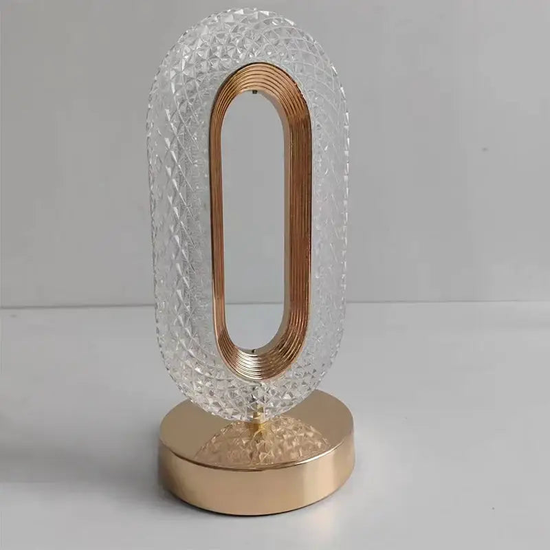 Oval gold crystal bedroom table lamp with clear diamond-cut body and copper metallic ring for decorbites crystal bedroom use