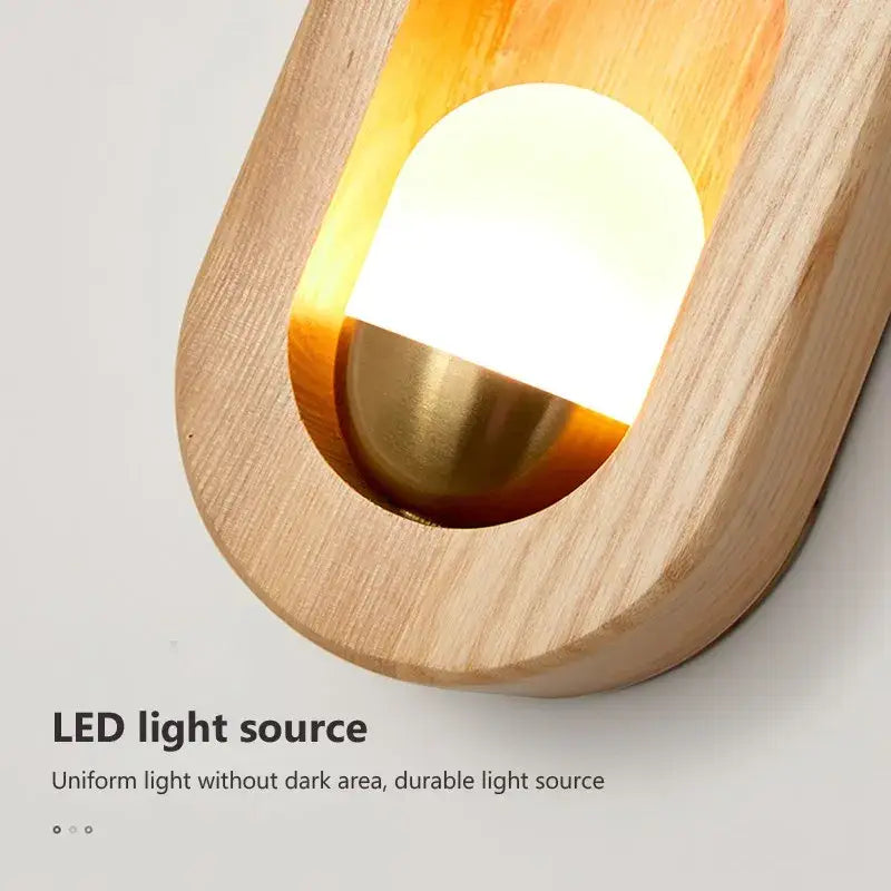 A warm amber oval led wooden wall lamp with natural wood frame and brass finish by decorbites led wooden wall