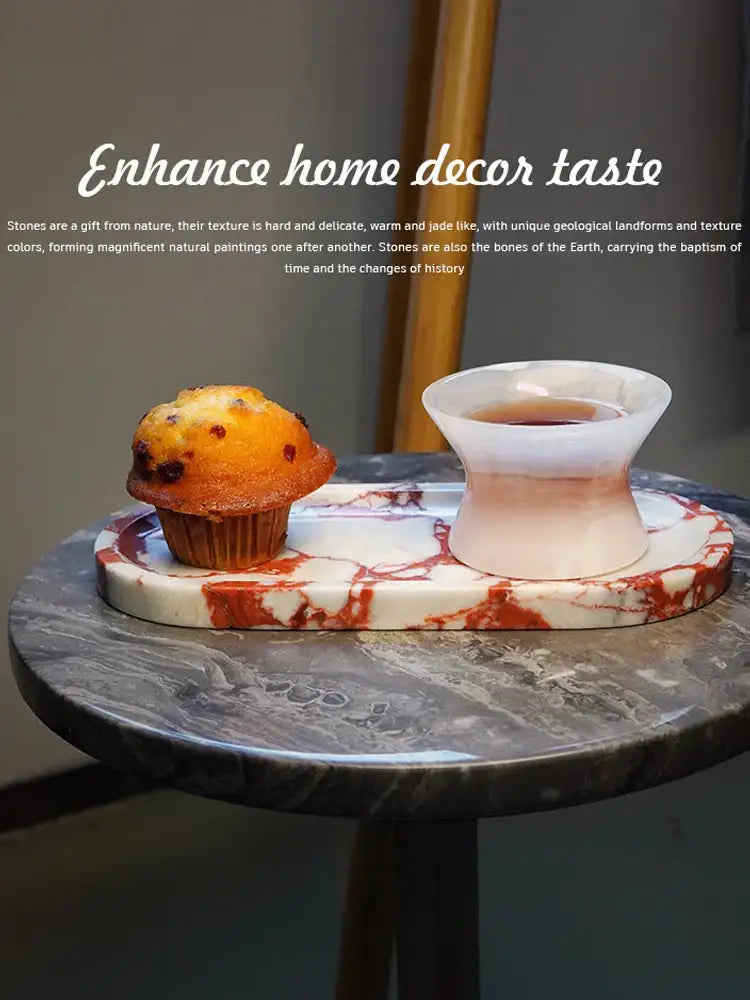 Rectangular white calacatta marble vanity tray with red veining holding a muffin and pinkish-white ceramic teacup decorbites calacatta marble