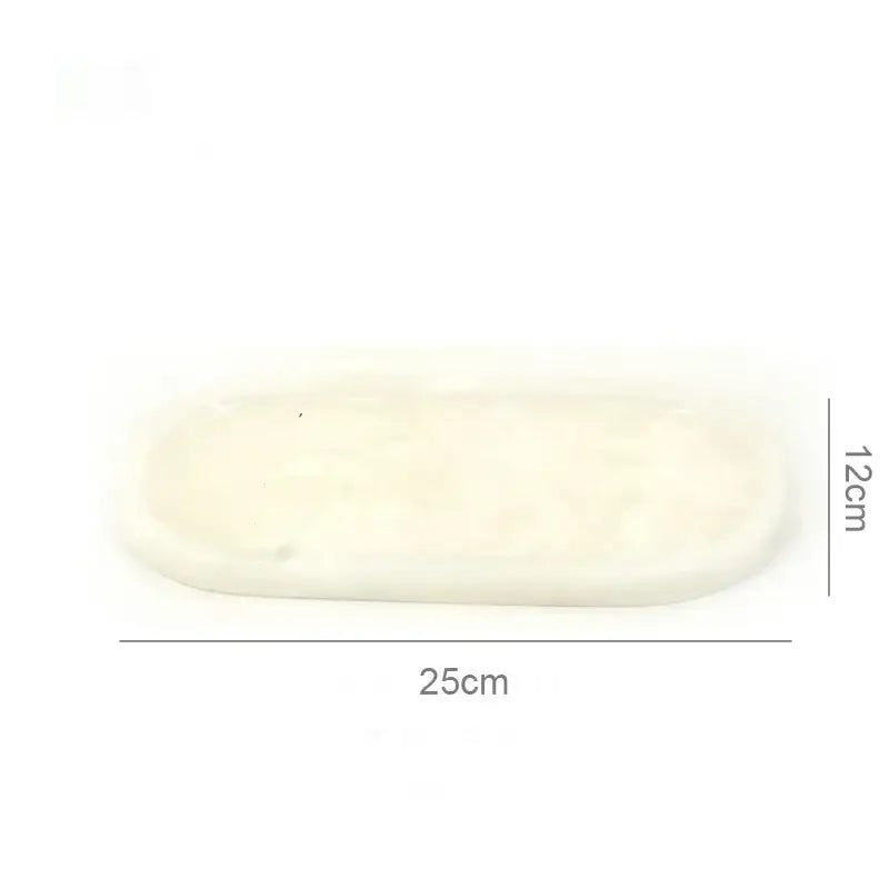 Cream-colored oval white Calacatta marble vanity tray with smooth textured surface and rounded edges for bathroom decorbites Calacatta marble use