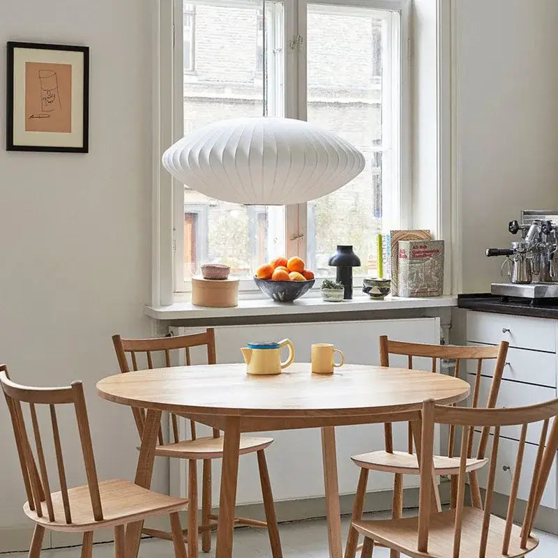 Oval white ribbed bubble silk pendant chandelier hanging above round wooden table for dining room decorbites bubble silk