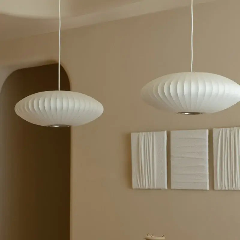 Two white oval ribbed bubble silk pendant chandeliers with a sleek modern design for dining room decorbites bubble silk