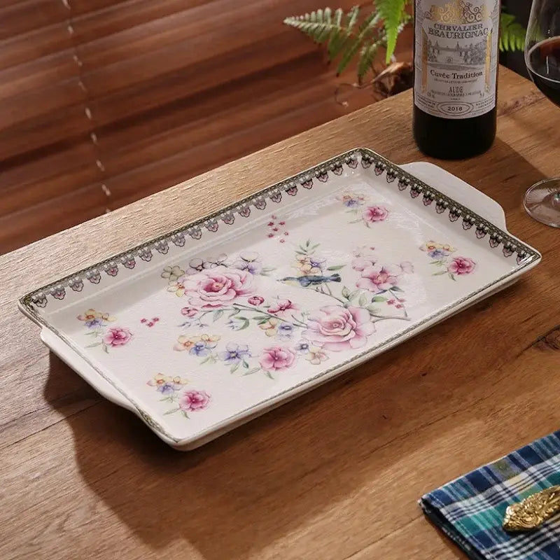 A rectangular ceramic ice crack tray with pink floral pattern and ornate black lace border for decorbites ice crack use