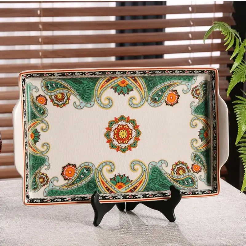 A rectangular ceramic ice crack tray with green and orange paisley patterns and central floral motif for serving