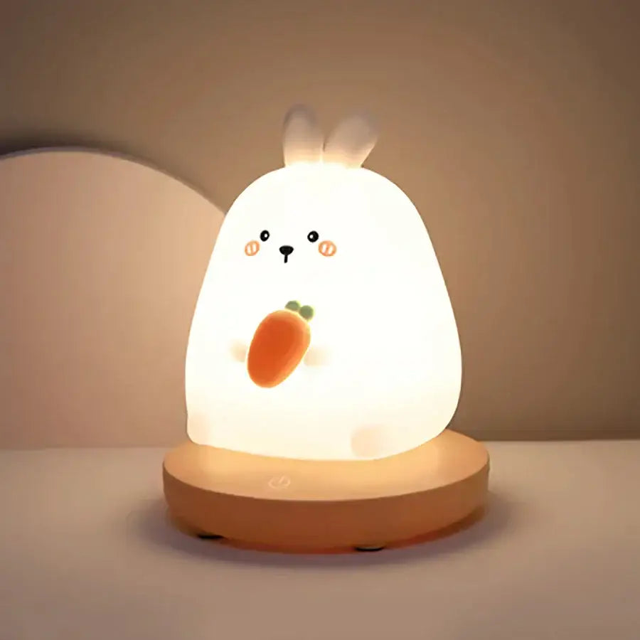 A soft glowing white rabbit kids animal silicone night light with carrot design and wooden base for bedroom decorbites decor