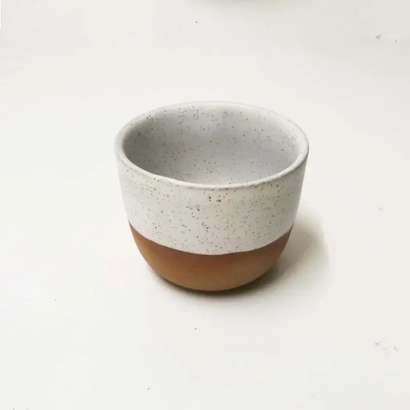 Minimalist ceramic tea cup with speckled white glaze and terracotta base from pastel and terracotta cup set
