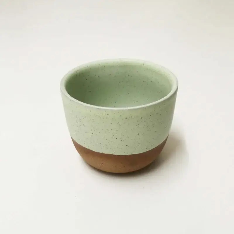 Minimalist ceramic tea cup with speckled sage green glaze and earthy brown base from pastel and terracotta cup set