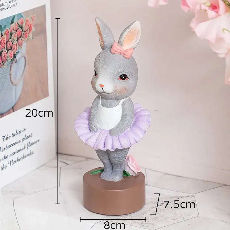 Gray rabbit dancer sculpture in lavender tutu and pink bow on brown base for pastel ballet rabbit dancer decor