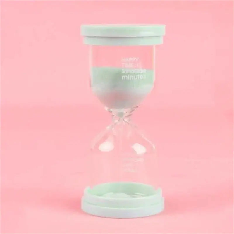 A mint green plastic-capped glass sand timer with printed text from a pastel blue and pink sand timer set for kids bedroom decor