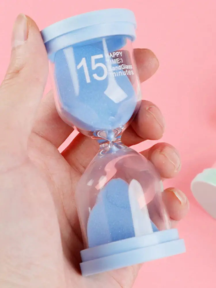 Pastel blue glass sand timer with light blue plastic lid marked 15 happy minutes in a kids bedroom timer set