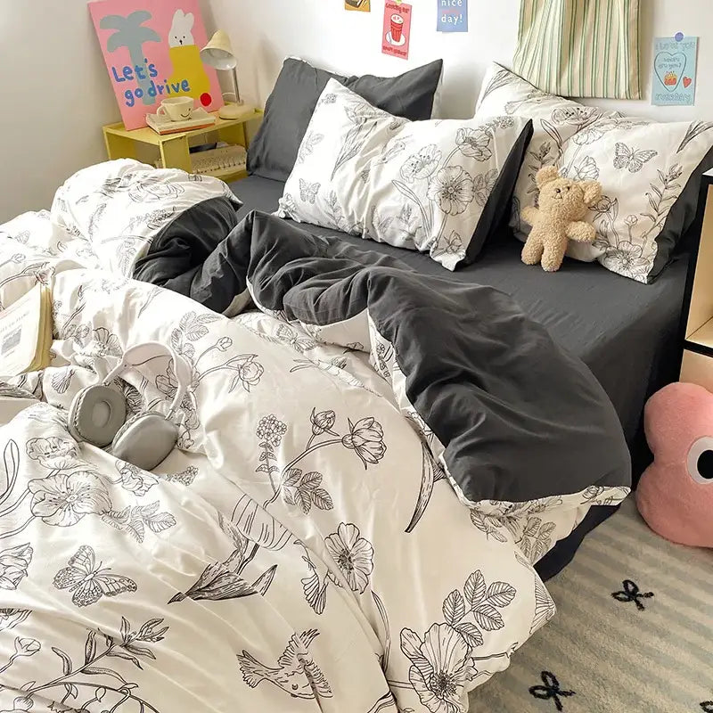 A cozy bedroom with bed sets featuring black and white floral duvet and decorbites cartoon pattern cotton sheets