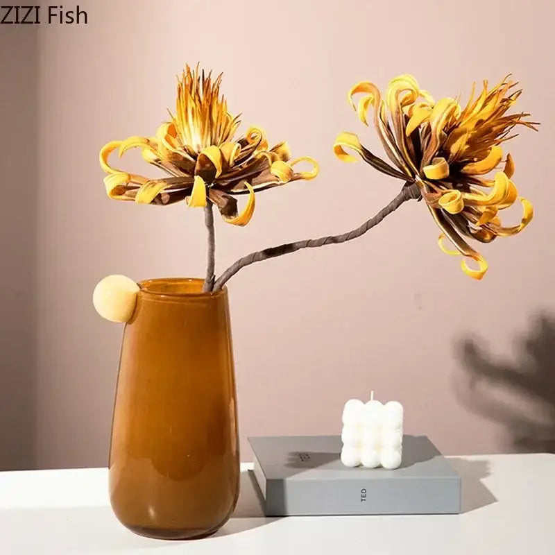 A sleek amber colorful glass vase with rounded handle and glossy finish for living room decor