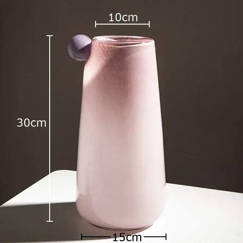 A sleek matte pink ceramic colorful glass vase with a rounded purple handle for living room decor